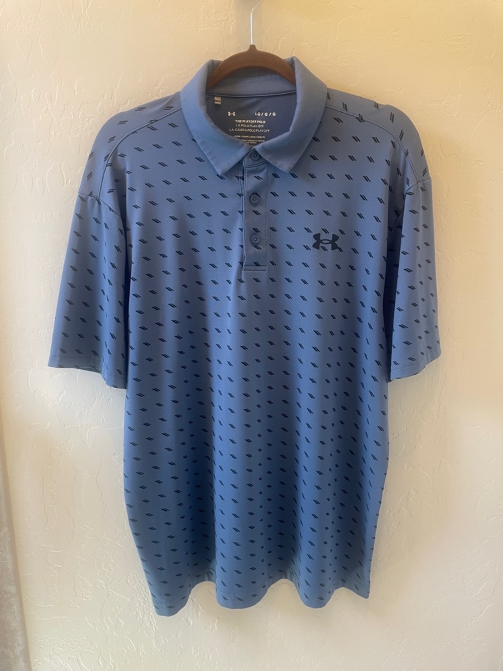 Size L Under Armour Men’s Slate Blue Polo with double backslash pattern.